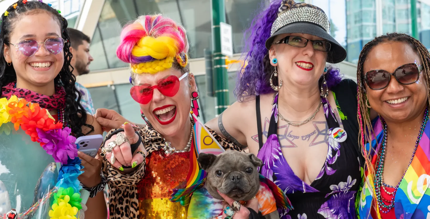 Group of diverse people celebrating Pride with colorful outfits and accessories.