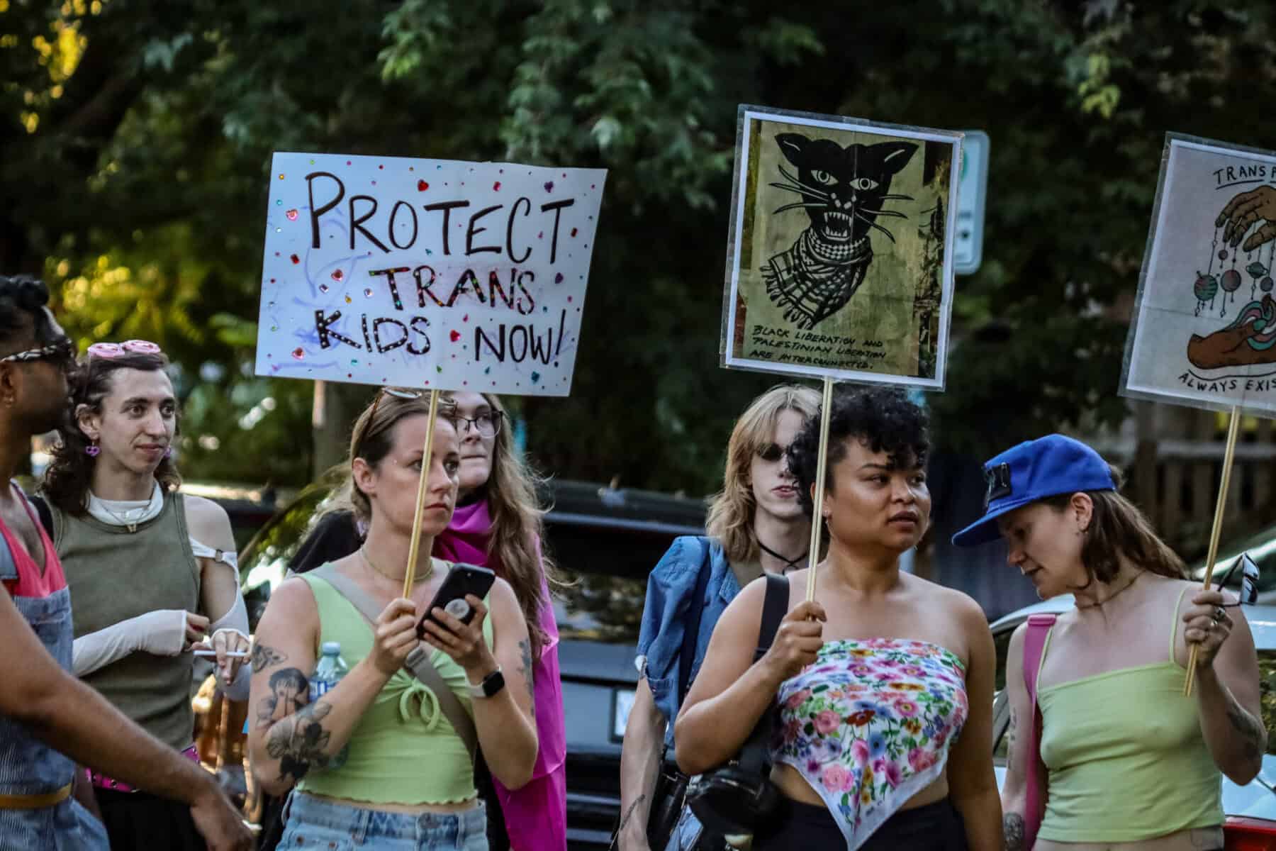 Protesters at Vancouver Trans March holding signs advocating for trans rights and protection.