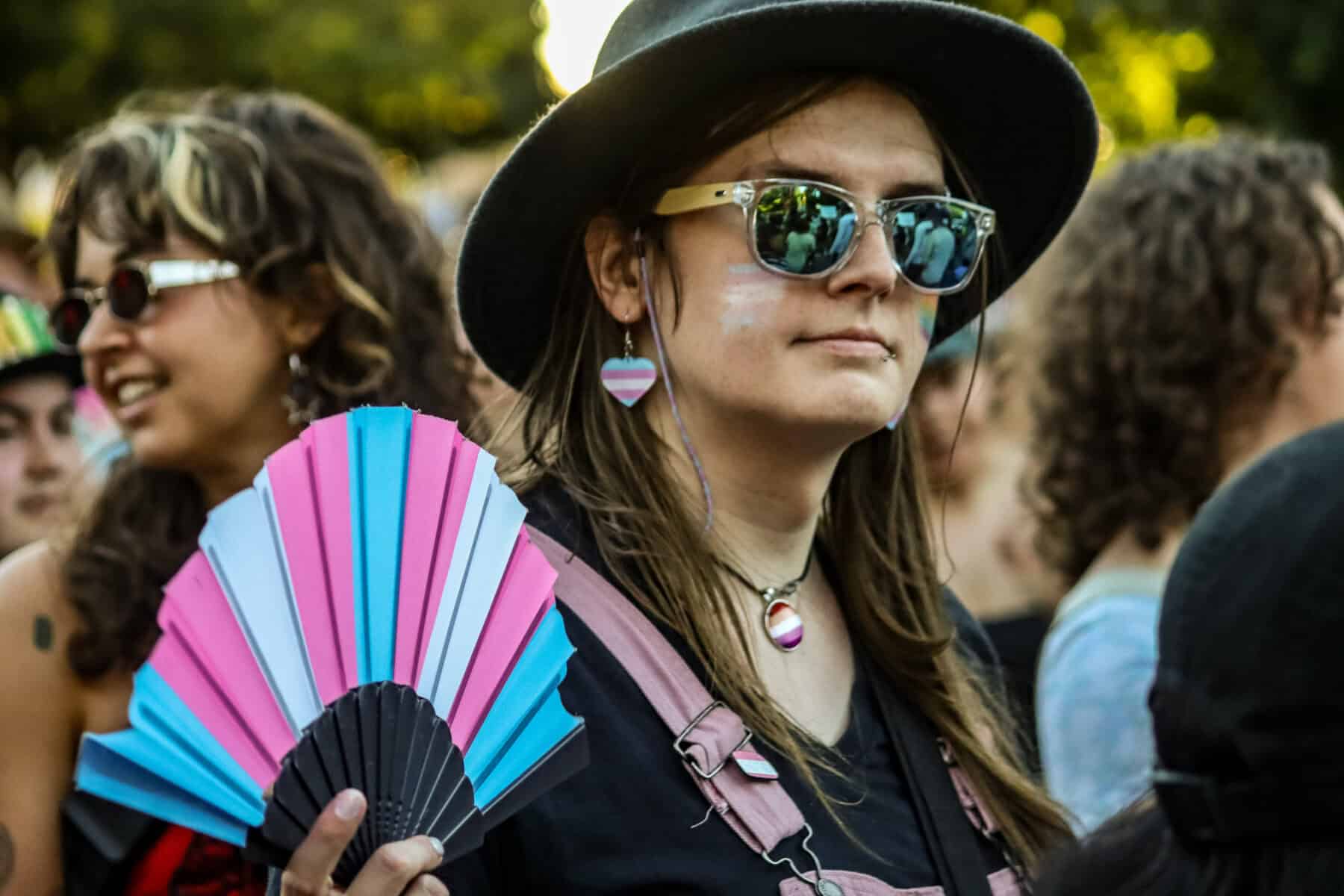 Woman with rainbow earrings and sunglasses at Vancouver Trans March.