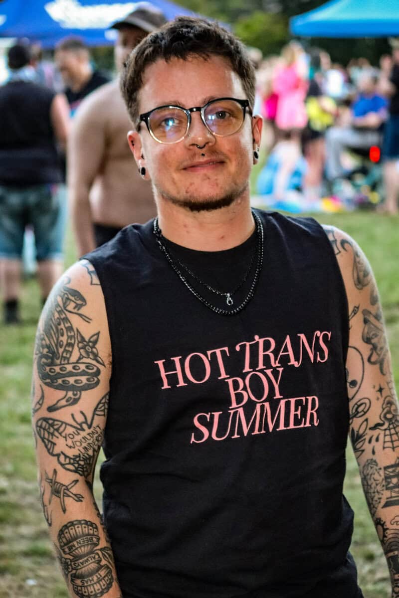Person with tattoos at Vancouver Trans March wearing 'Hot Trans Boy Summer' shirt.