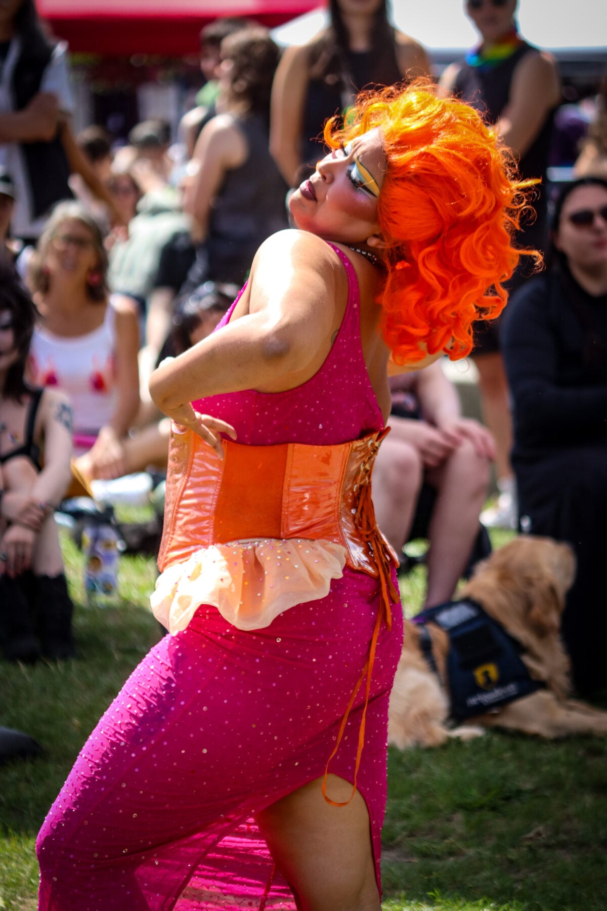 Colorful performer with bright orange hair at outdoor event in Canada.