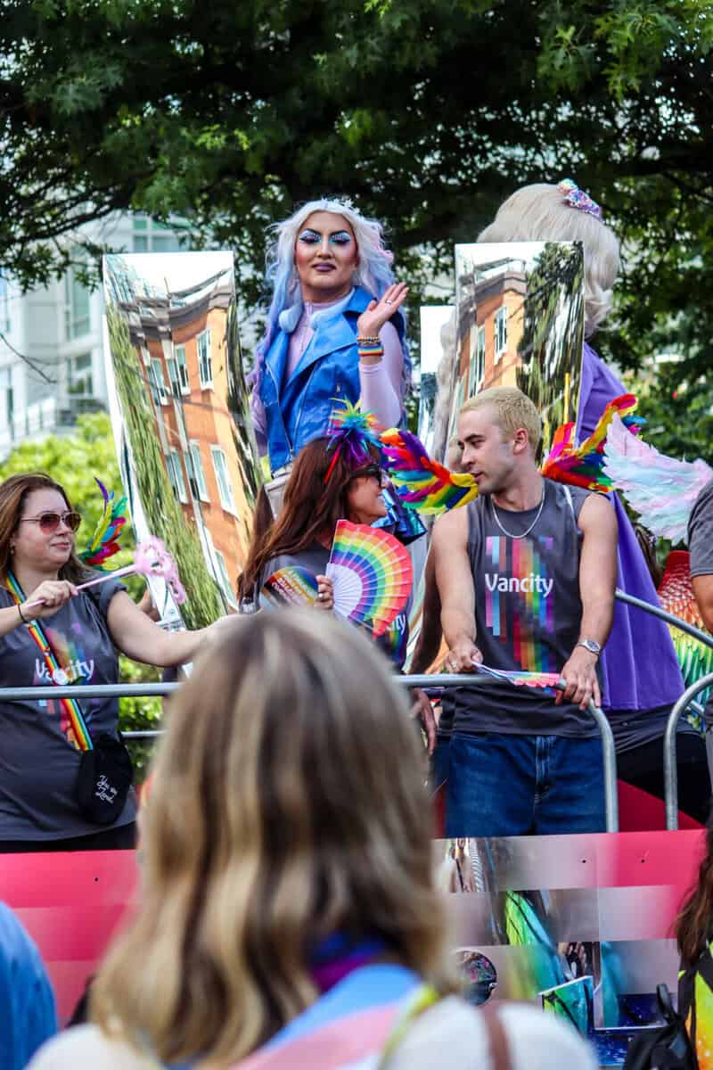 LGBTQ pride parade with colorful costumes and rainbow flags in Vancouver, Canada.
