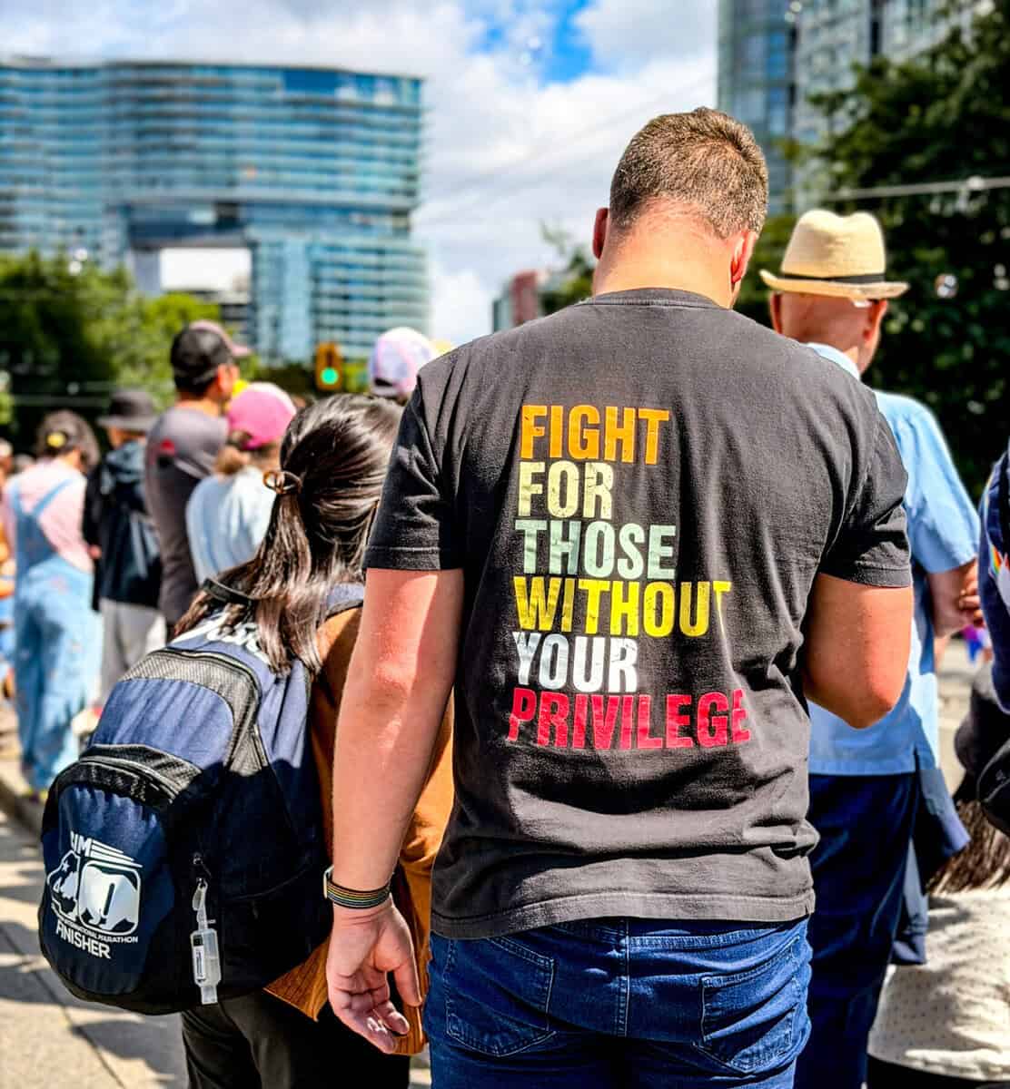 Protestor wearing a black T-shirt with 'Fight for Those Without Your Privilege' in bold letters.