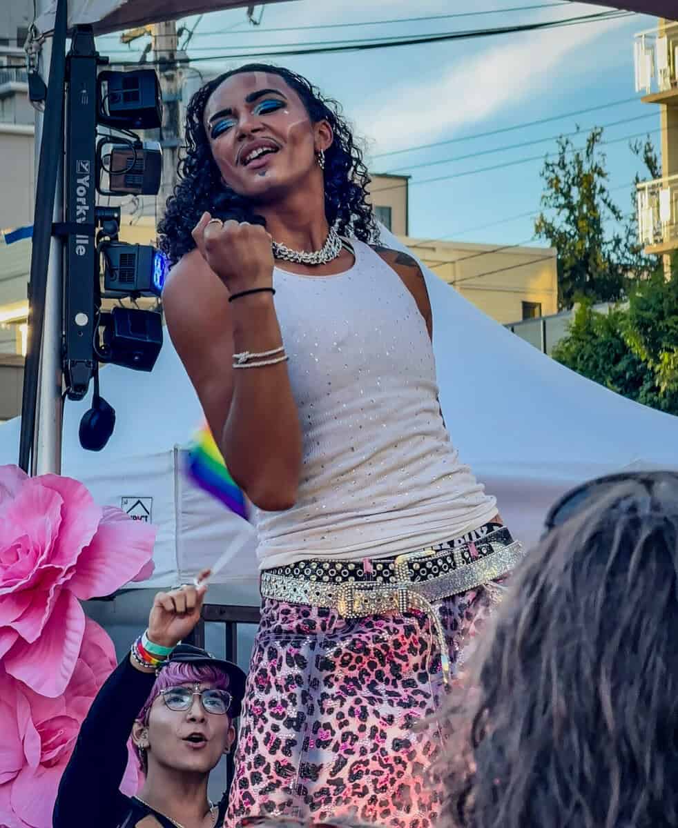 Celebrating Pride with a joyful performer on stage at Now Canada event.