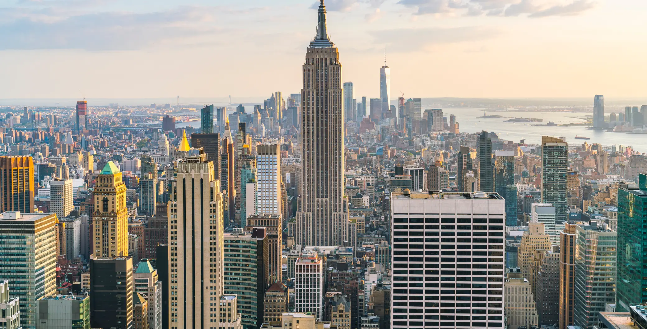 View of New York City skyline with Empire State Building at sunset.