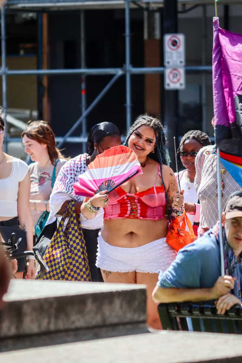 LGBTQ+ pride parade with diverse participants and rainbow flags in downtown.