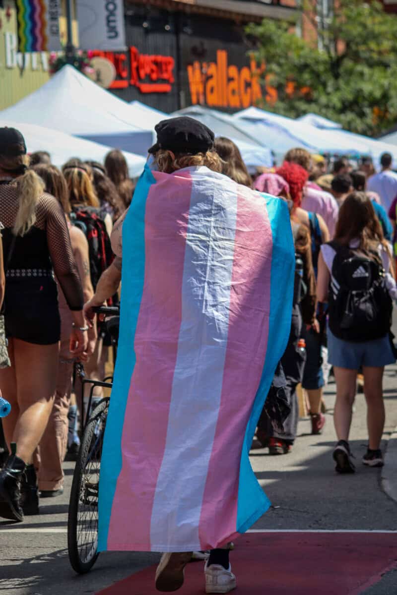 Person with a transgender pride flag at a pride parade in Canada.